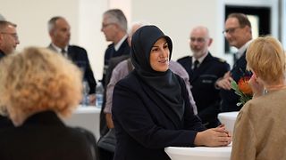 Gäste an Stehtischen im Foyer