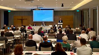 Landtagspräsident Thomas Strobl spricht in einem Konferenzraum vor den versammelten Synodalen