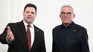 Landtagspräsident Strobl und Dr. András Izsák, Generalkonsul von Ungarn, schauen lächelnd auf etwas links der Kamera. Dr. Iszák gestikuliert lebhaft, während er etwas sagt.