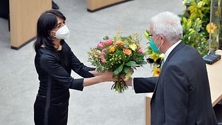 Alterspräsident Winfried Kretschmann überreicht Landtagspräsidentin Aras einen Blumenstrauß