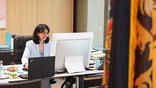 Präsidentin Muhterem Aras vor ihrem Computer mit der Fahne Baden-Württembergs