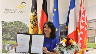 Landtagspräsidentin Aras zeigt die unterschriebene Absichtserklärung