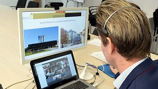 Dr. Deppisch vom Besucherdienst des Landtags vor seinem Laptop mit den Zuhörerinnen und Zuhörern