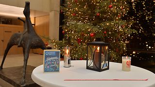 Das Friedenslicht vor dem Weihnachtsbaum in der Lobby des Landtags