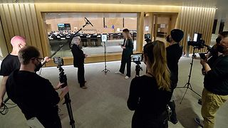 Die Moderatorin spricht mit Aktivistinnen vor dem Plenarsaal