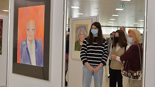 Gäste vor dem Porträt von Daniel Born