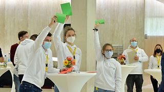 Jugendliche halten grüne Zustimmungs-Zettel hoch