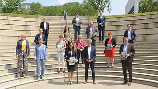 Die Vorsitzende des Wissenschaftsausschusses Nese Erikli und einige Ausschussmitglieder nehmen den Bibliotheksentwicklungsplan Baden-Württemberg 2021 von einer Delegation des Bibliotheksverbands - Jürgen Bim, Andrea Krieg, Dr. Katharina Ebrecht, Beate Meinck, Volker Schebesta und Dr. Frank Mentrup - entgegen