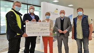 Vizepräsident Daniel Born übergibt den Teilnehmern symbolisch einen Scheck.